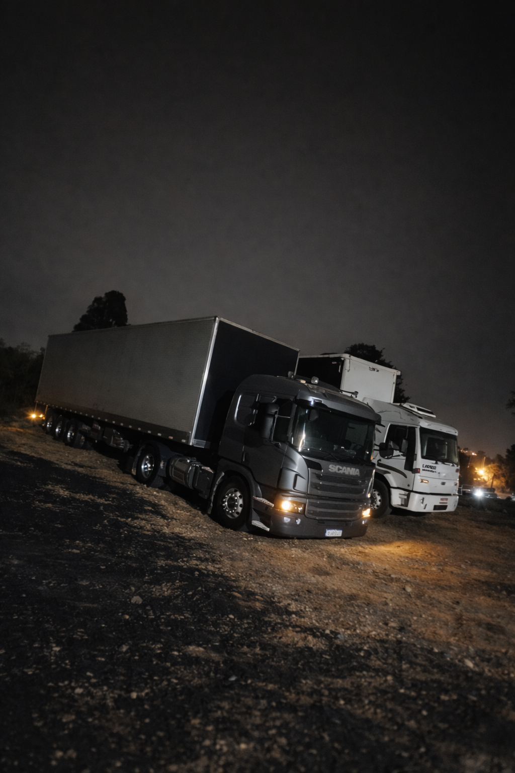 Caminhão Scania e carreta estacionados à noite
