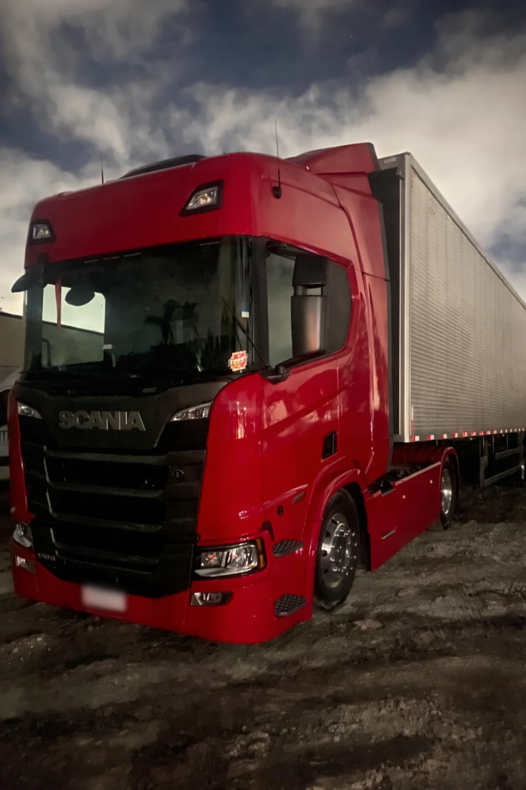 Scania vermelha com carreta no pátio